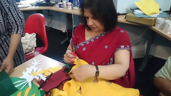 a woman in a sari cutting yellow felt