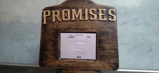 The top of the Promises and Wishes Machine with a screen and a sign saying 'Promises'